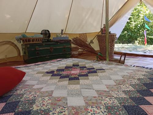 a bedroom with a quilt on a bed in a tent at Tenda romantica nel Noccioleto in Castellero