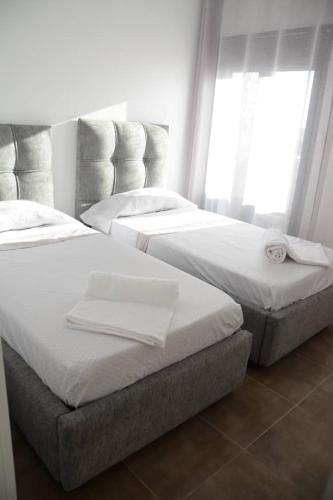 two twin beds in a room with windows at Le Fabuleux Mazagran in Mostaganem