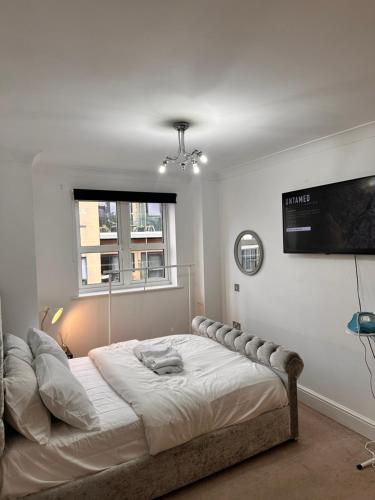 a bedroom with a large bed with a television on the wall at Enjoy city living in this one-bedroom flat, complete with a balcony and secure parking in Birmingham city center in Birmingham