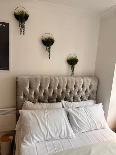a bed with a tufted headboard in a bedroom at Enjoy city living in this one-bedroom flat, complete with a balcony and secure parking in Birmingham city center in Birmingham