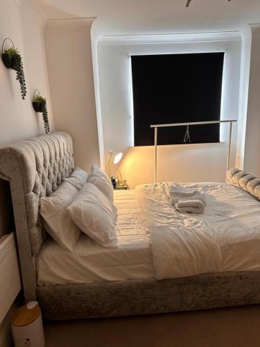 a large bed in a room with a window at Enjoy city living in this one-bedroom flat, complete with a balcony and secure parking in Birmingham city center in Birmingham