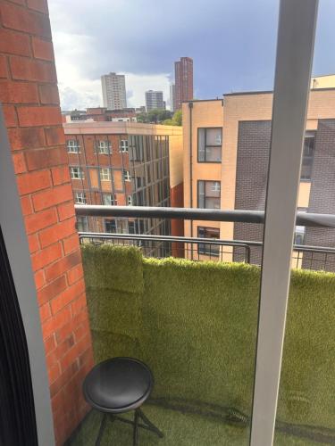 a chair on a balcony with a view of the city at Enjoy city living in this one-bedroom flat, complete with a balcony and secure parking in Birmingham city center in Birmingham