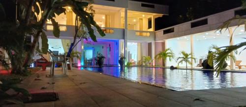 a house with a swimming pool at night at Mangroven River View Hotel in Bentota