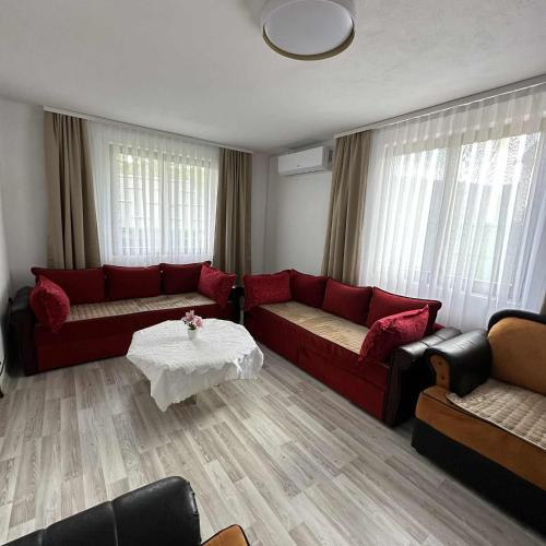 a living room with a red couch and a table at Holiday home Mumi in SJJ