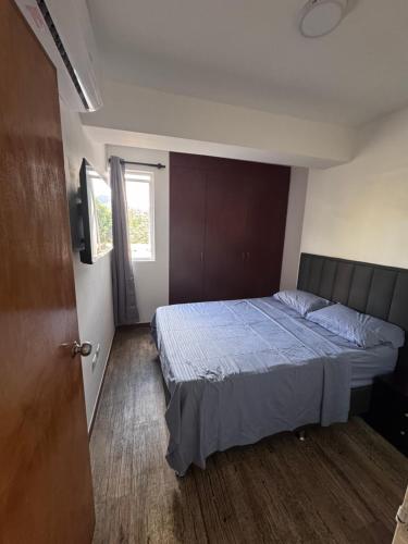 a bedroom with a bed and a window at Apartamento zona Hesperia Sambil Complejos Deportivos in Naguanagua