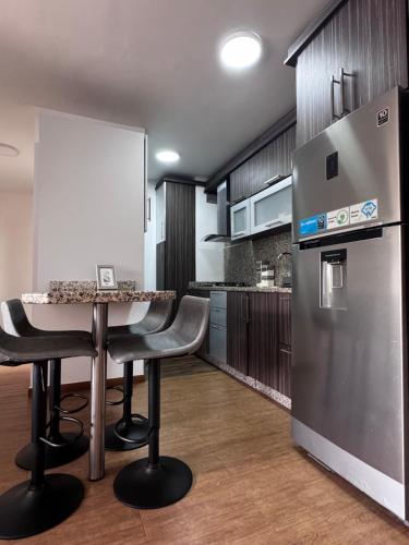 a kitchen with a table and a refrigerator at Apartamento zona Hesperia Sambil Complejos Deportivos in Naguanagua