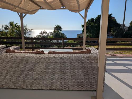 a wicker table with an umbrella on the beach at Skala Bay 1 in Skala Kefalonias