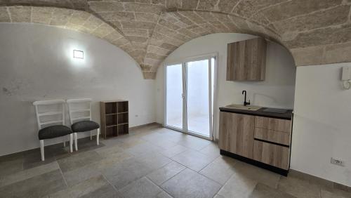 a kitchen with a stone ceiling with two chairs and a counter at Le Volte di Dante in Parabita