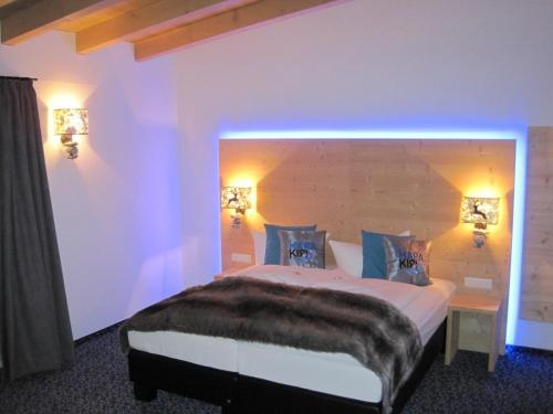 a bedroom with a large bed with two lights at Harakiri Partyhouse in Mayrhofen