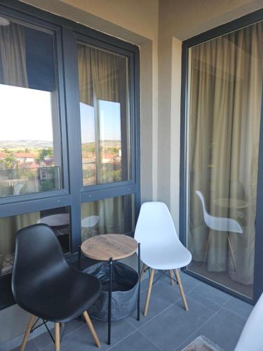 a room with two chairs and a table and two windows at Lux Mimi Apartments in Skopje