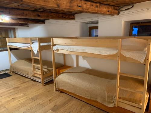 two bunk beds in a room with wooden floors at Chalet Sauce Montagnarde in Planay