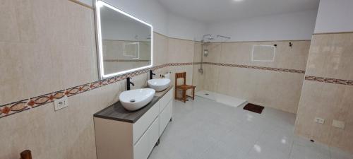 a bathroom with two sinks and a mirror at VILLA La TOSCA in Vega de San Mateo