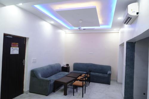 a waiting room with a table and a couch at The Essence Suite, 500 metro from Iffco chowk metro station in Gurgaon