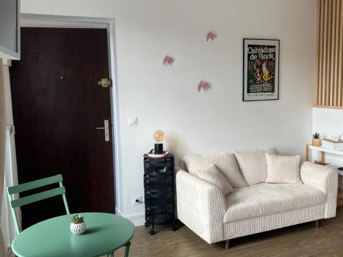 a living room with a couch and a table at Chez Max in Bayeux