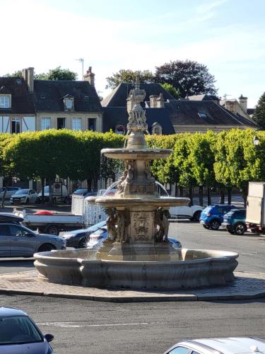 a fountain in the middle of a parking lot at Chez Max in Bayeux