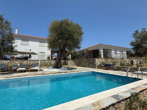 a swimming pool in front of a house at Villa Afroditi, Skiathos, Kalivia, Greece in Skiathos National Airport