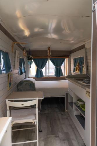 a small caravan with a bed and a kitchen in it at JABUTI Autocaravana con porche y aparcamiento in Cádiz