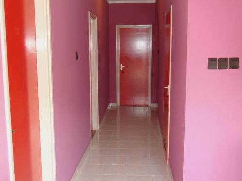 a hallway with pink walls and a red door at FANNI vízközeli, klimatizált Vendégház in Balatonboglár