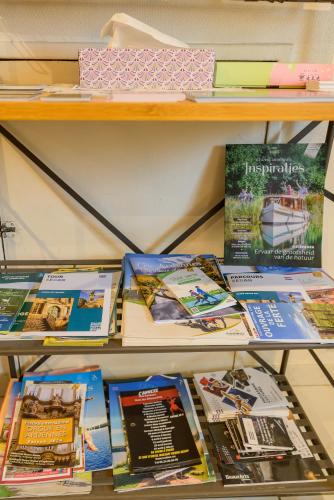 a shelf with many books on it at l'Entracte, enjoy a 3 stars break in Sedan in Sedan