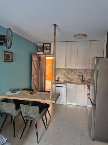 Una cocina con una mesa de madera y un refrigerador. en Sea Nest, en Pafos