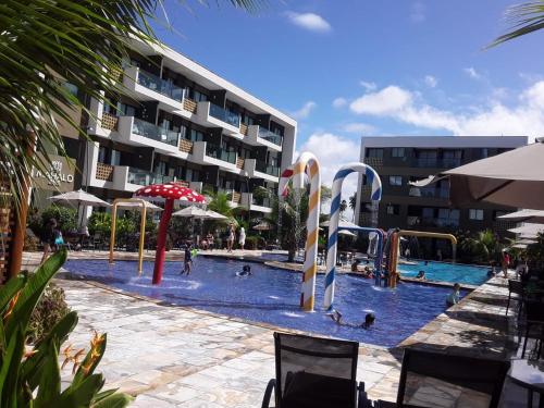 uma grande piscina com pessoas a brincar nela em Flat em Porto de Galinhas em Porto de Galinhas