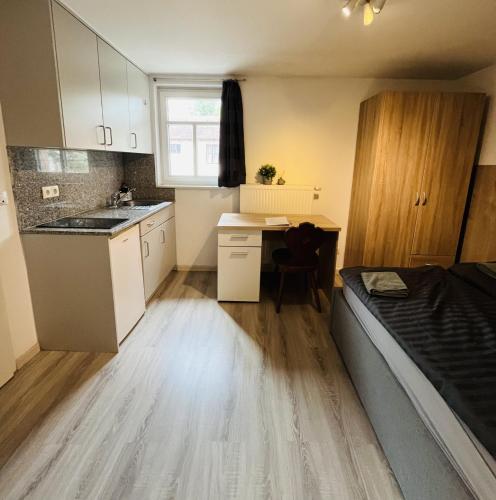 a small room with a kitchen and a bed at Seebachstuben - gemütliche Mehrzimmerapartments in Dechsendorf in Erlangen