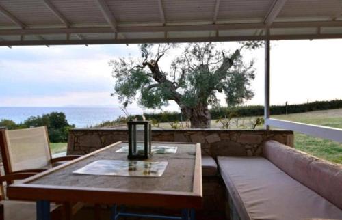 a table and a couch with a view of the ocean at Aegean View Maisonette in Neos Marmaras