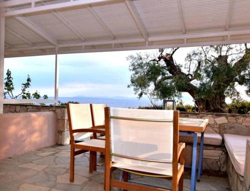 two chairs and a table under an umbrella on a patio at Aegean View Maisonette in Neos Marmaras