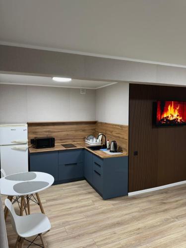 a kitchen with a table and a fire in the wall at Апартаменты в самом центре города in Balqash