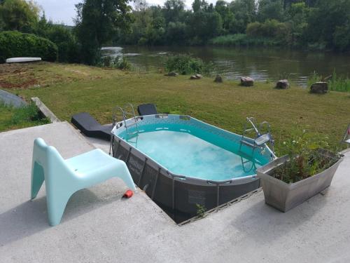 - une piscine avec une chaise et une table dans l'établissement Maison Bord de Seine, à Belbeuf