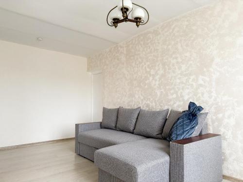 a living room with a gray couch and a wall at Baltic Breeze apartment in Liepāja