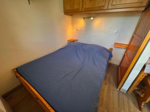 Ce lit se trouve dans un dortoir doté d'un drap bleu. dans l'établissement Appartement Confort 4 Pers., Balcon Sud-Ouest, Reberty 1850, Proche Pistes et Commerces - FR-1-452-261, aux Menuires
