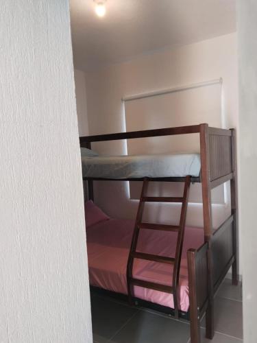 a bunk room with a bunk bed and a ladder at Acapulco Diamante in Cedro
