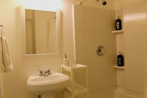 a white bathroom with a sink and a shower at Newly Renovated Basement with Private Bathroom in Herndon