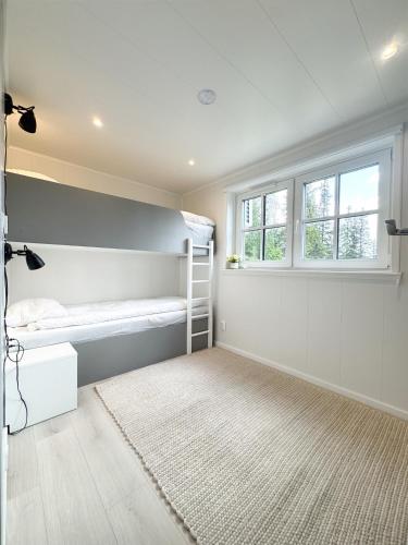 a bedroom with a bunk bed and a window at Mysig, Prisvärd Stuga i Borgafjäll - Borgaporten in Borgafjäll