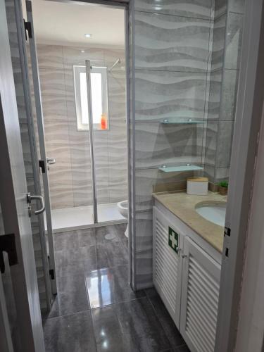 a bathroom with a shower and a toilet and a sink at Marina Biarrits in Vilamoura