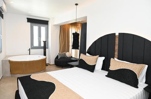 a bedroom with a large bed and a bath tub at ASTREA Relax Suites in Adamas