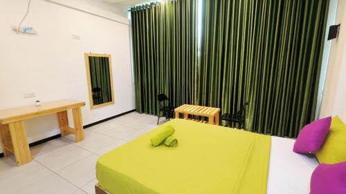 a living room with a green couch and a table at Riverline Resort Kandy in Kandy