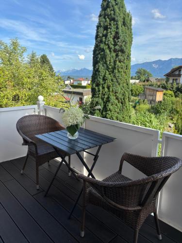 a table and chairs on a deck with a view at Ferienwohnung Julia - Ruhelage mit Panoramablick in Villach