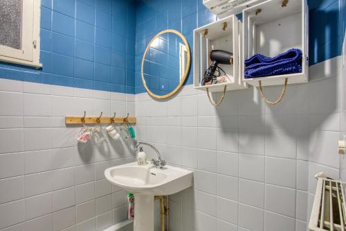a blue and white bathroom with a sink and mirror at Maison 3 ch calme, jardin, Le nid des Chênes in Saint-Julien-de-Lampon