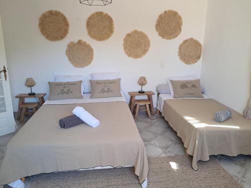 deux lits dans une chambre avec des paniers de foin au mur dans l'établissement La maison de Manon, 4-5personnes, 75m2, centre village avec piscine privée, à Maussane-les-Alpilles
