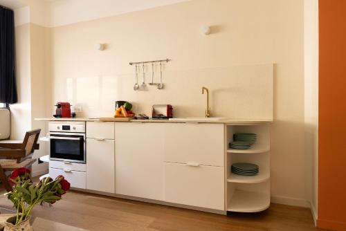 une cuisine avec des armoires blanches et un évier dans l'établissement Jardin des Plantes - Amazing 2BR 4P apartment, à Paris
