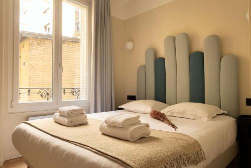 une chambre avec un lit avec des serviettes dessus dans l'établissement Jardin des Plantes - Amazing 2BR 4P apartment, à Paris