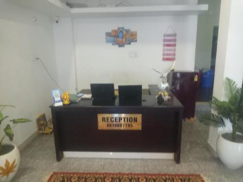 an office with a reception desk with a sign on it at La township stay in Puducherry