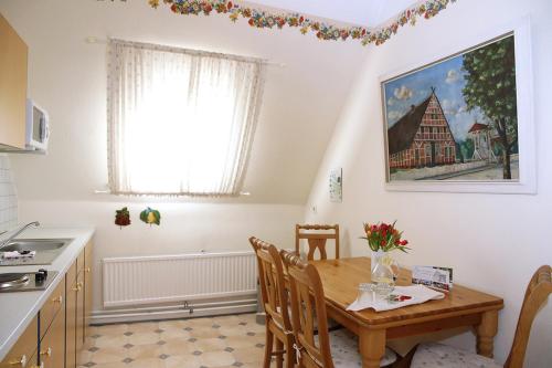 a kitchen with a wooden table and chairs in a room at Gästehaus Rieper in Jork
