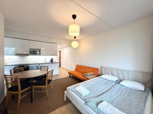 a bedroom with a bed and a table and a kitchen at Easy Stay Rooms & Apartments near Airport in Vantaa