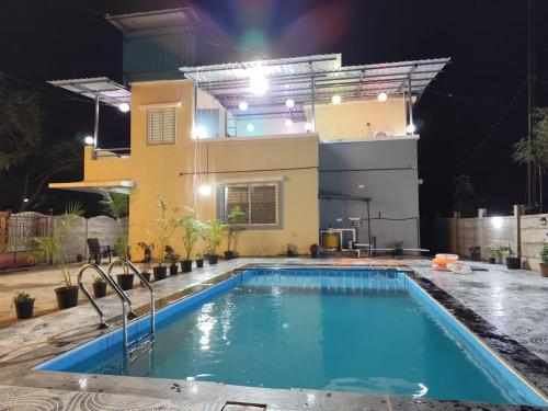 une piscine devant une maison la nuit dans l'établissement Nvalai Villa with Swimming pool, à Panchgani