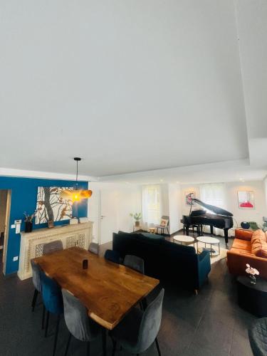 a living room with a table and a piano at Villa Exclusive in Strasbourg