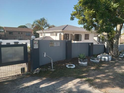 a white fence in front of a house at Gabade Guest House in KwaDukuza