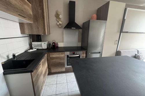 Il comprend une cuisine équipée d'un comptoir noir et d'un réfrigérateur. dans l'établissement Apartment 2 rooms with Wifi in the heart of Nice, à Nice